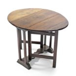 A 17th century-style small oak drop-leaf table with slender end supports & shaped centre stret