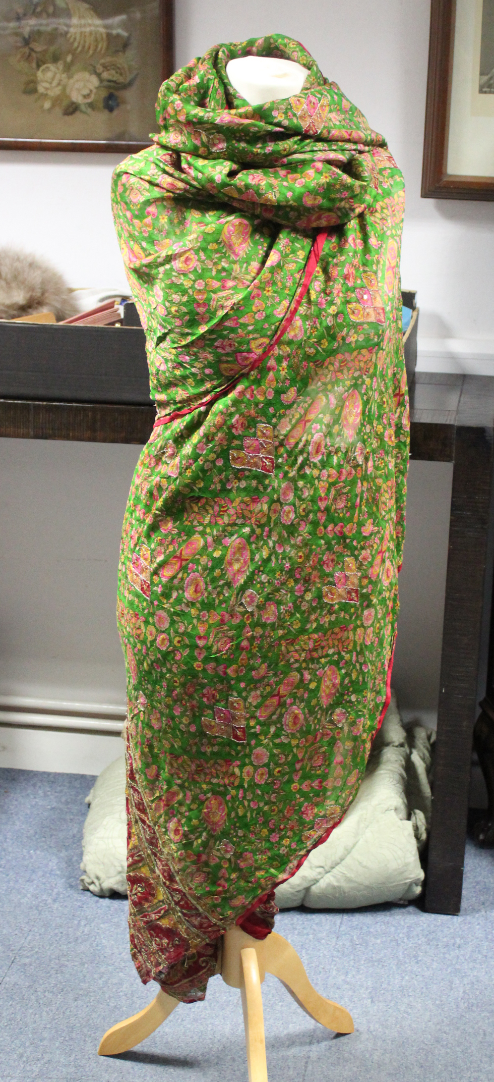 An Indian sari of green & crimson ground with all-over floral & scroll design to one end & with