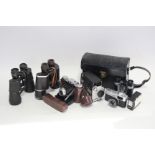 An Adox folding camera; an Olympus “Trip 35” camera; a Bell & Howell movie camera; & three pairs