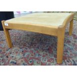 An Ercol light elm stool with a beige fabric upholstered top and concave sides, raised on turned,