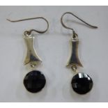 A pair of white metal earrings,