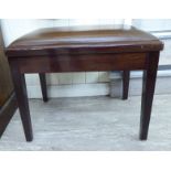 A modern mahogany framed piano stool with a faux brown hide, height adjustable seat,
