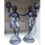 A pair of early 20thC Spelter Blackamoor dancing figures, each carrying a water vessel,
