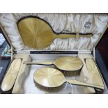A five piece dressing table set with silver and engine turned sand coloured enamel backs