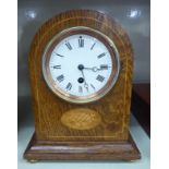A 1920s string inlaid light oak cased mantel timepiece with a marquetry motif,