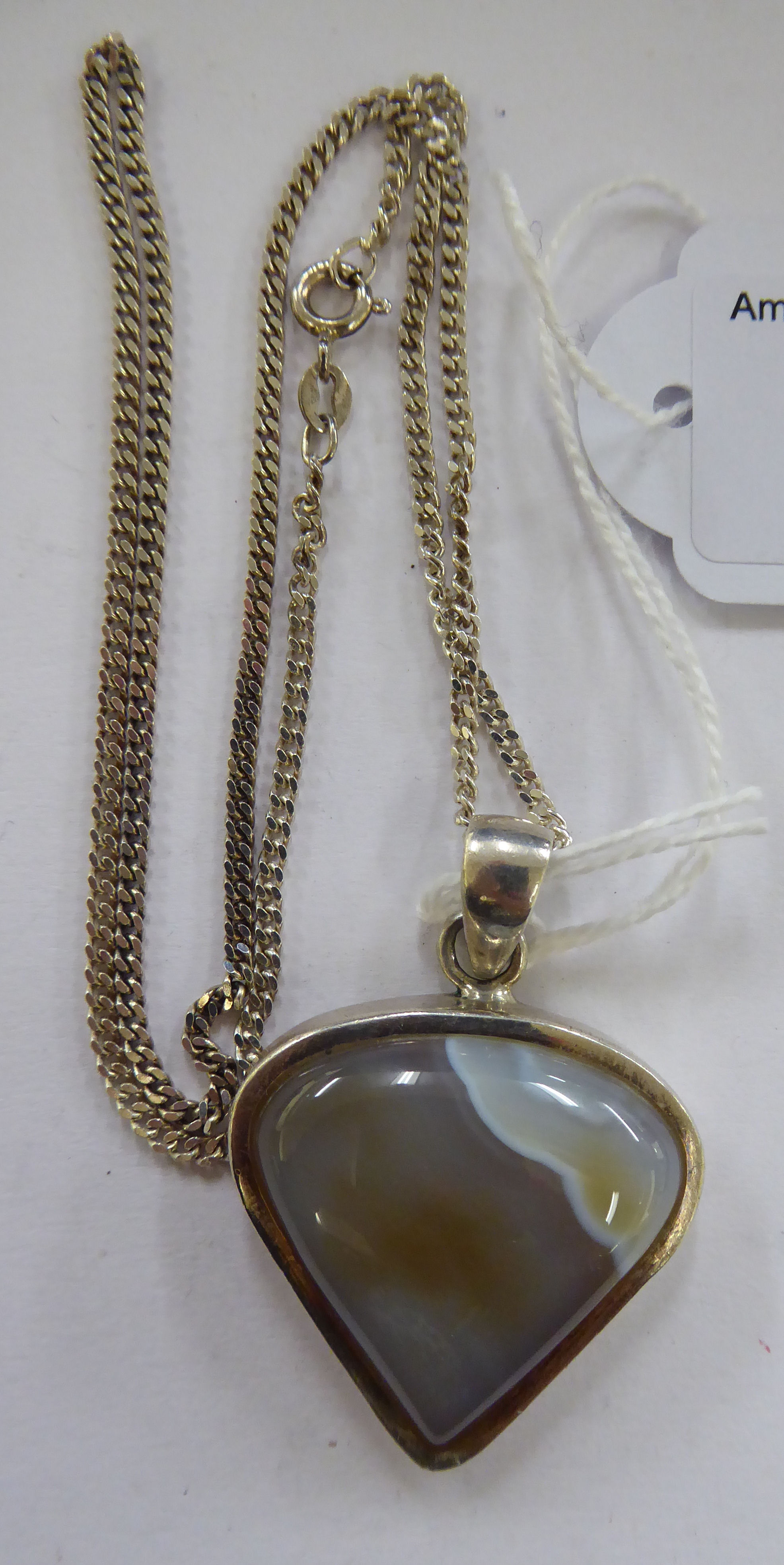 A white metal pendant, set with triangular shaped agate,