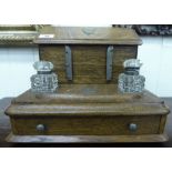 An early 20thC light oak desktop stationary box with an angled, hinged lid,