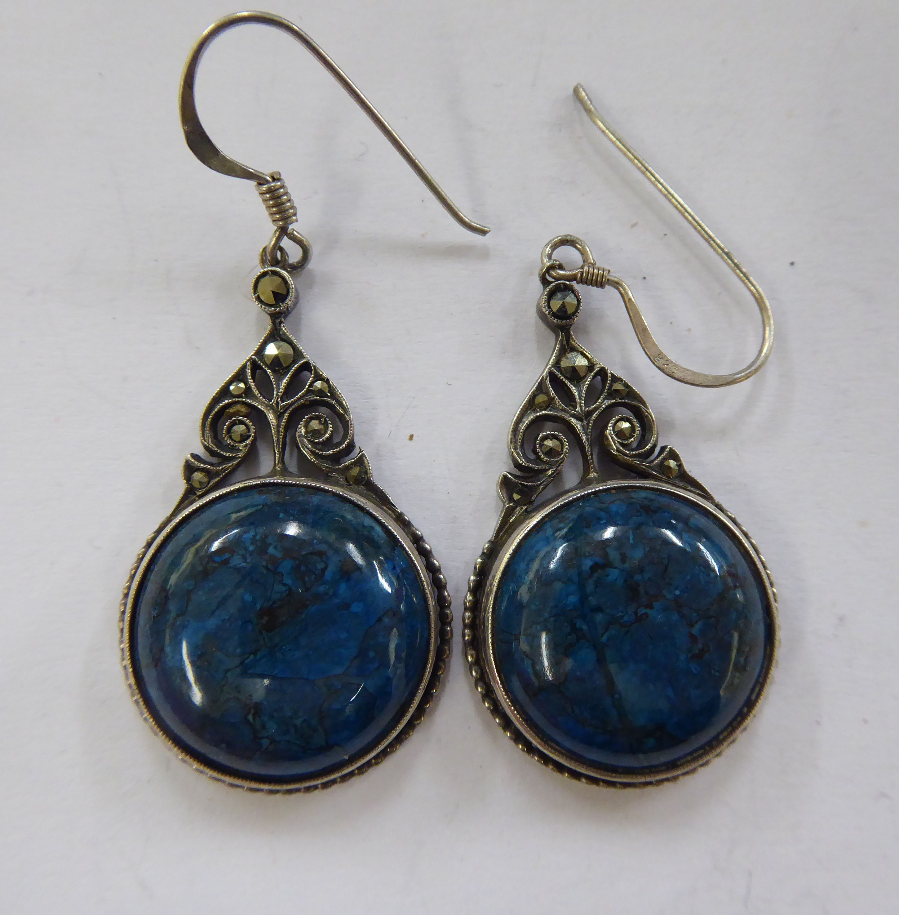 A pair of white metal earrings,