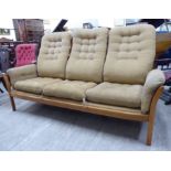 An Ercol light elm framed three person settee,