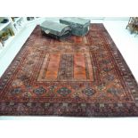 A Persian carpet with a central gul motif on a red and blue ground 106'' x 180'' S