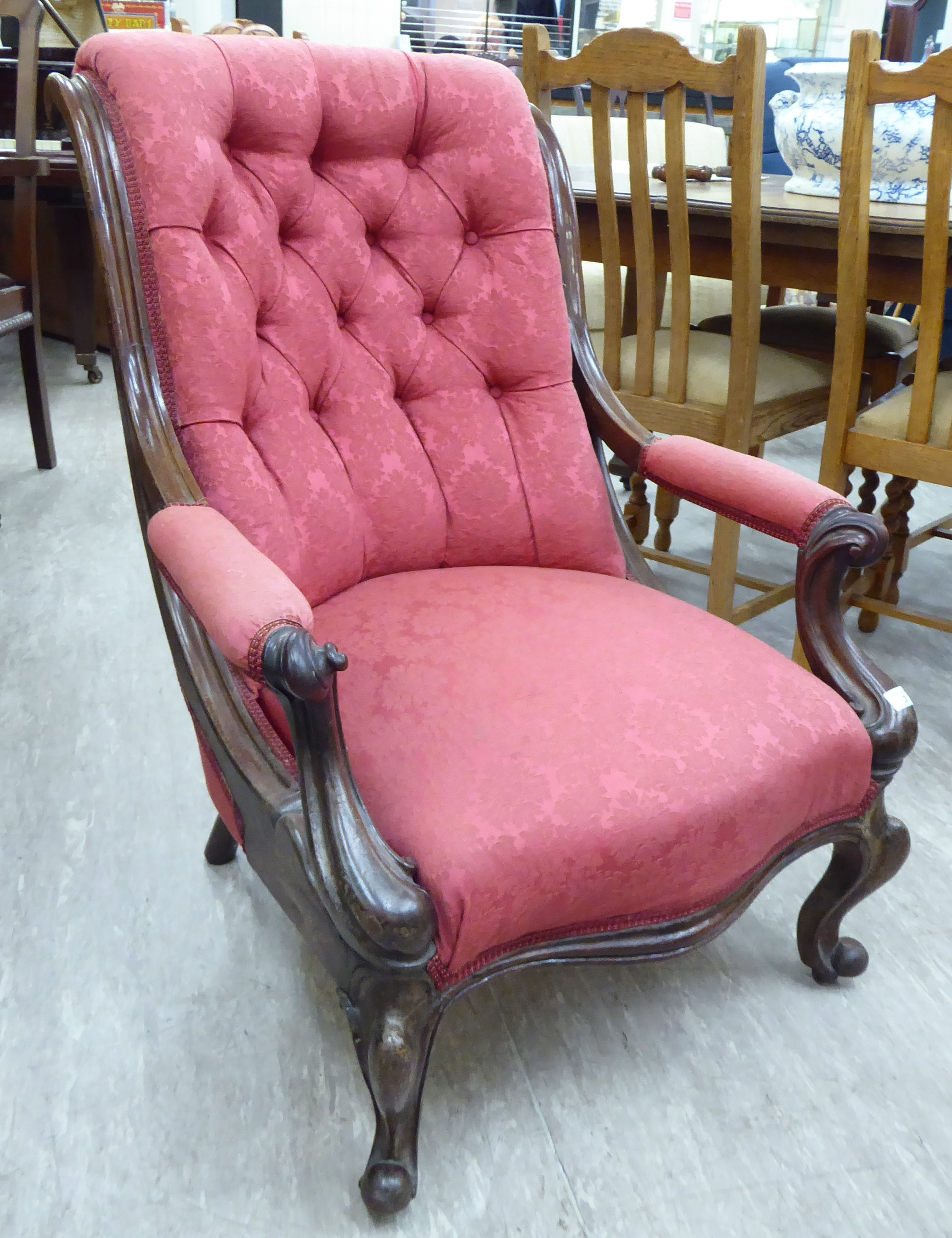 A late Victorian mahogany showwood framed armchair with a scroll moulded, high,