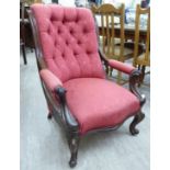 A late Victorian mahogany showwood framed armchair with a scroll moulded, high,
