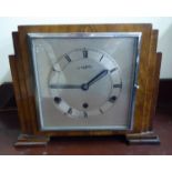 An Art Deco walnut veneered cased mantel clock with stepped sides,