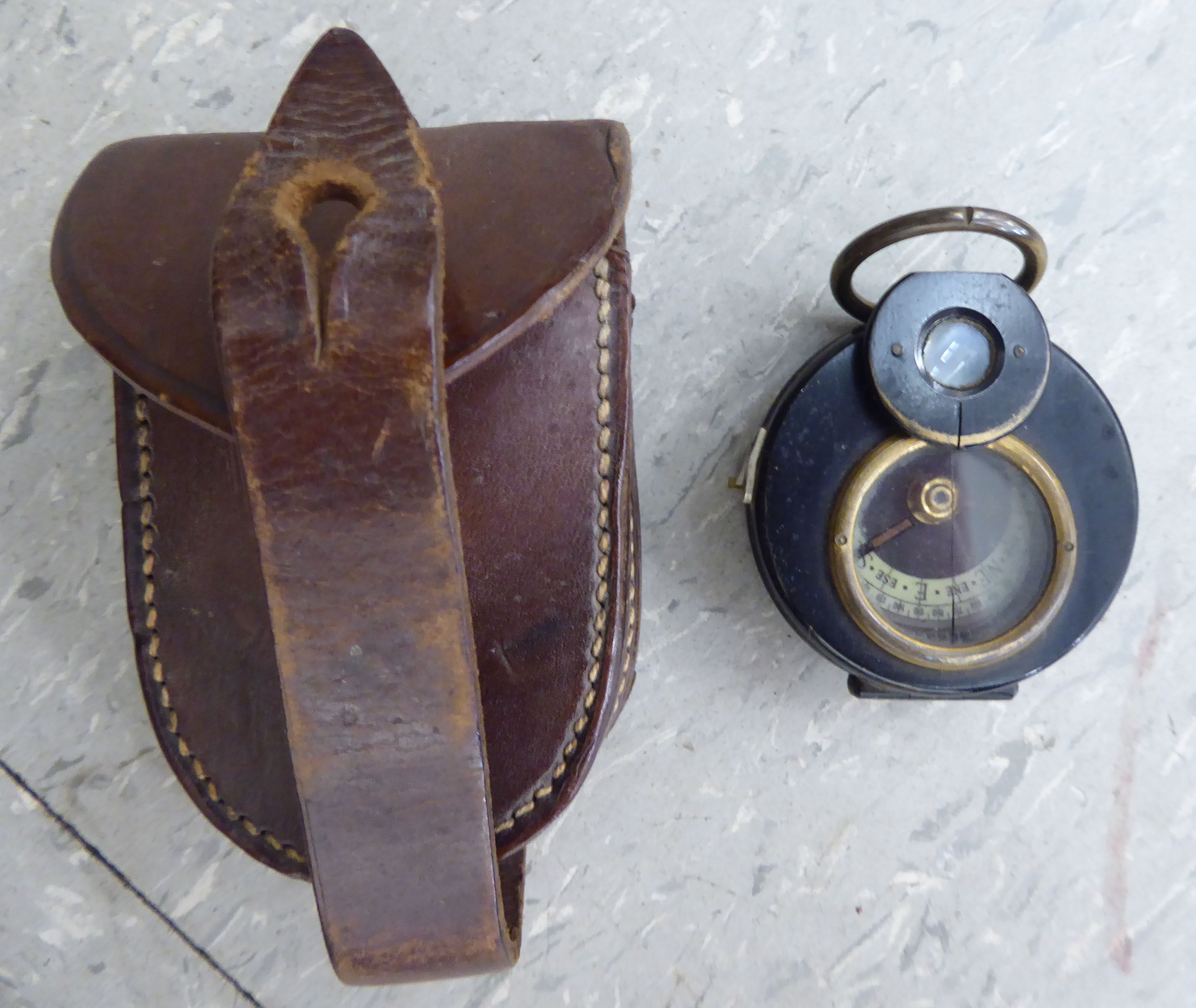 An early 20thC black lacquered brass cased pocket barometer, in a moulded,