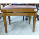 A modern stained beech framed piano stool with a faux brown hide height adjustable seat,