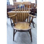A late 19th/early 20thC beech and elm framed Windsor high spindle back, open arm chair,