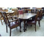 A 1920s oak wind-out dining table, the top with rounded corners,