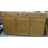 An Ercol light elm sideboard with two drawers and three panelled doors,