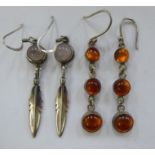 Two similar pairs of white metal earrings,