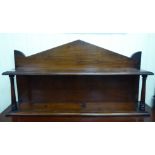 A late Victorian mahogany hanging shelf with an arched, boarded backplate and narrow shelf,