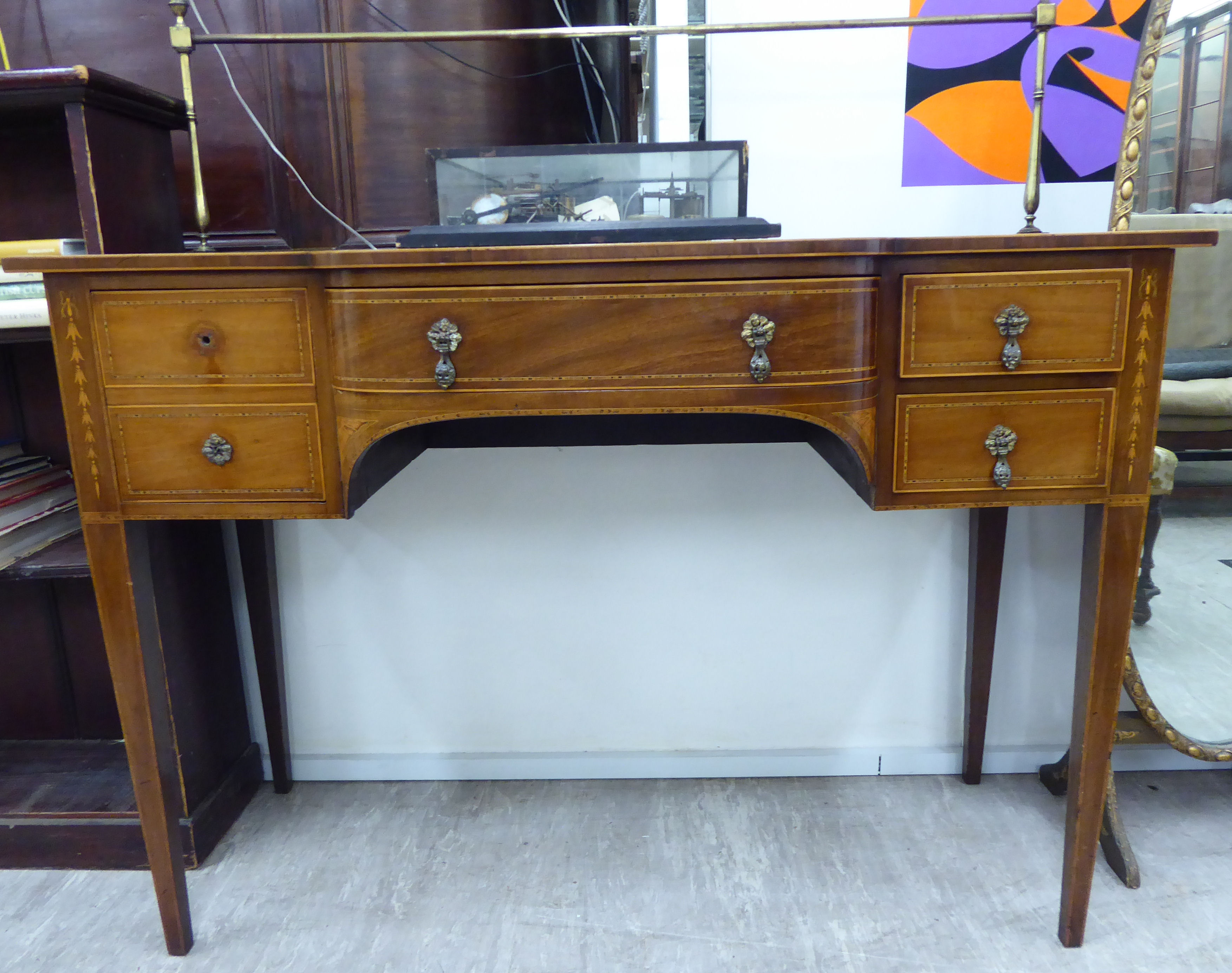 An Edwardian ebony and string inlaid breakfront sideboard with a brass galleried upstand,