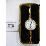 A lady's 9ct gold cased wristwatch, faced by an enamelled Arabic dial,
