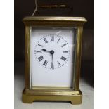 An early/mid 20thC lacquered brass cased carriage timepiece with bevelled glass panels and a