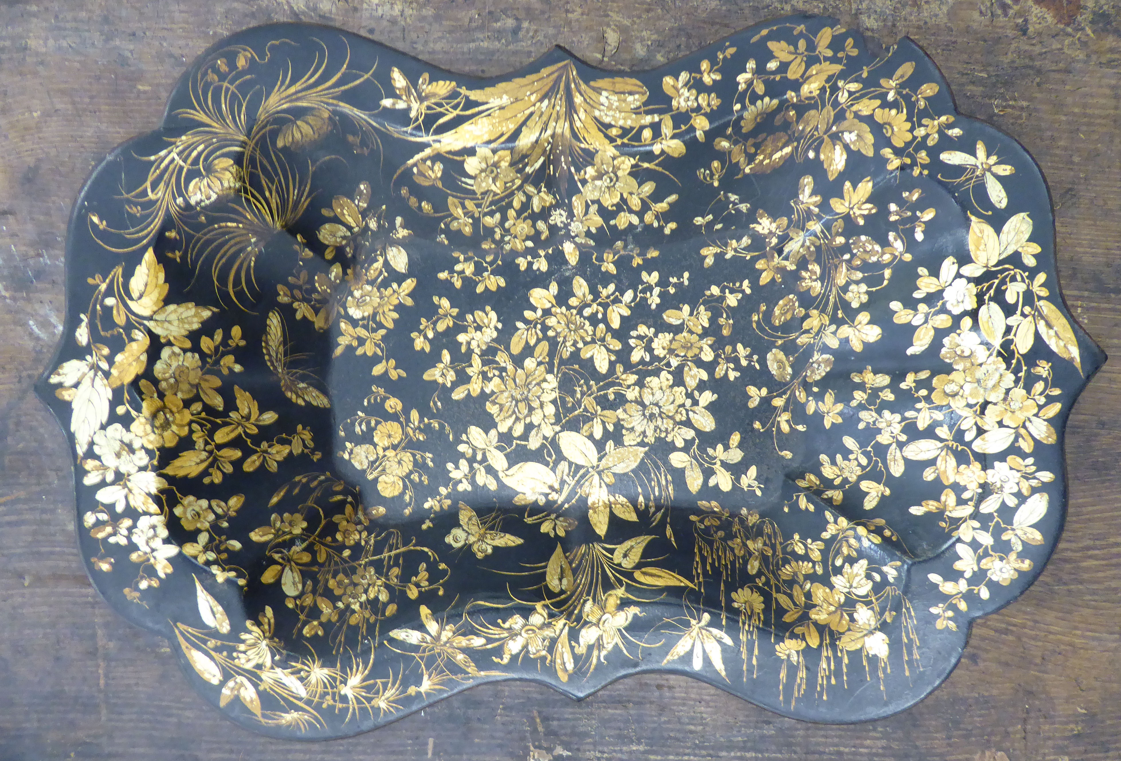A late Victorian black lacquered papier mache dish of oval, segmented and lobed form,
