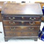 An early 19thC country made oak bureau with brass fittings,
