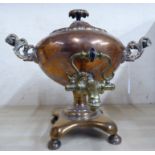 A late 19thC copper and brass samovar with opposing bar handles, turned wooden grip,