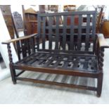 A 1920s oak framed two person reclining settee with loose cushion covers LAF