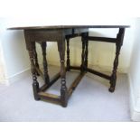 A late 18thC oak drop leaf dining table, the underside ornately carved with lunette motifs,