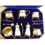 An Edwardian seven piece silver condiments set of cauldron design,