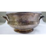 A silver bowl of shallow ogee form with opposing handles,