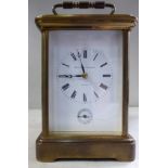 A mid 20thC lacquered brass cased carriage clock with bevelled glass panels and a folding top