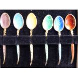 A set of six Art Deco inspired silver gilt and engine turned enamel coffee spoons with scroll cast
