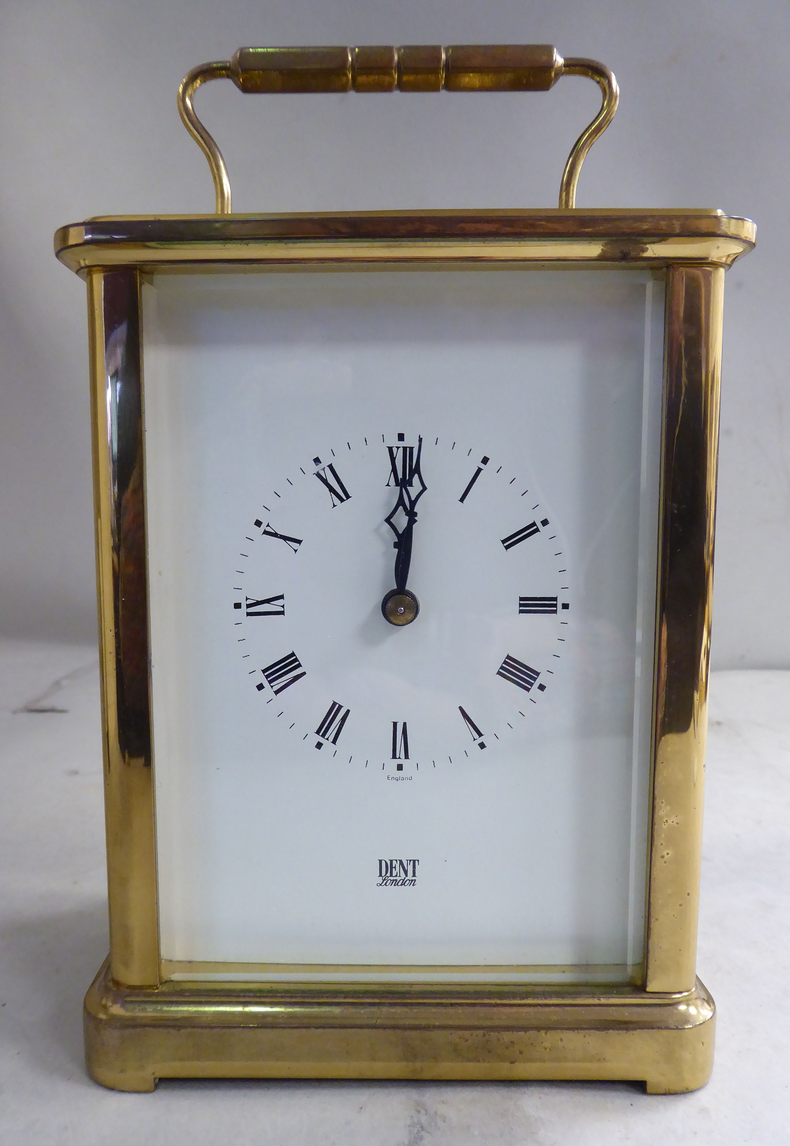 A mid 20thC lacquered brass cased carriage clock with bevelled glass panels and a folding top