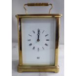 A mid 20thC lacquered brass cased carriage clock with bevelled glass panels and a folding top