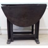A late 17thC country made oak trestle gateleg table, the planked and dowelled,