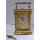 An early 20thC gilt metal cased carriage clock with bevelled glass panels,