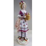 A late 19th/early 20thC Naples porcelain figure, a young woman wearing a floral pinafore dress,