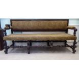 A mid 19thC country made upholstered oak bench settee with a level, low back, open arms,