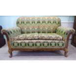 A 1920s/30s walnut showwood framed settee, having a level back and scrolled arms,