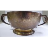 A silver shallow bowl with opposing, hollow, tab-top handles, on a splayed footrim,