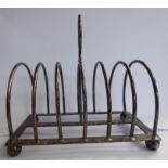 A late Victorian silver six division, hooped wire toastrack with a central ring handle,