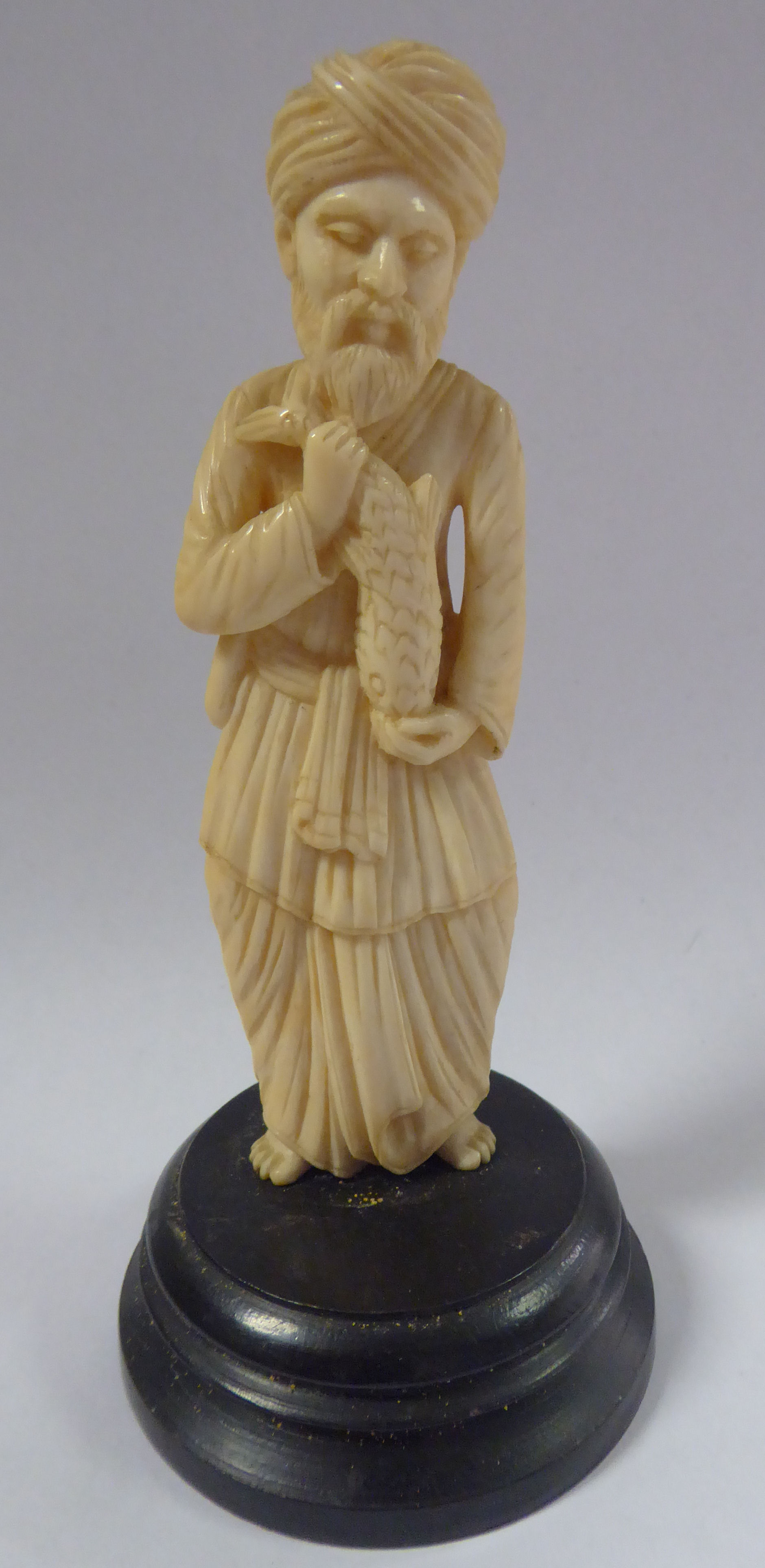 An early 20thC Asian carved ivory standing figure, a bearded man, wearing a turban and robes,