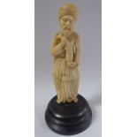 An early 20thC Asian carved ivory standing figure, a bearded man, wearing a turban and robes,