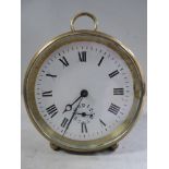 An early 20thC lacquered brass cased mantel clock of drum design with a folding ring handle,