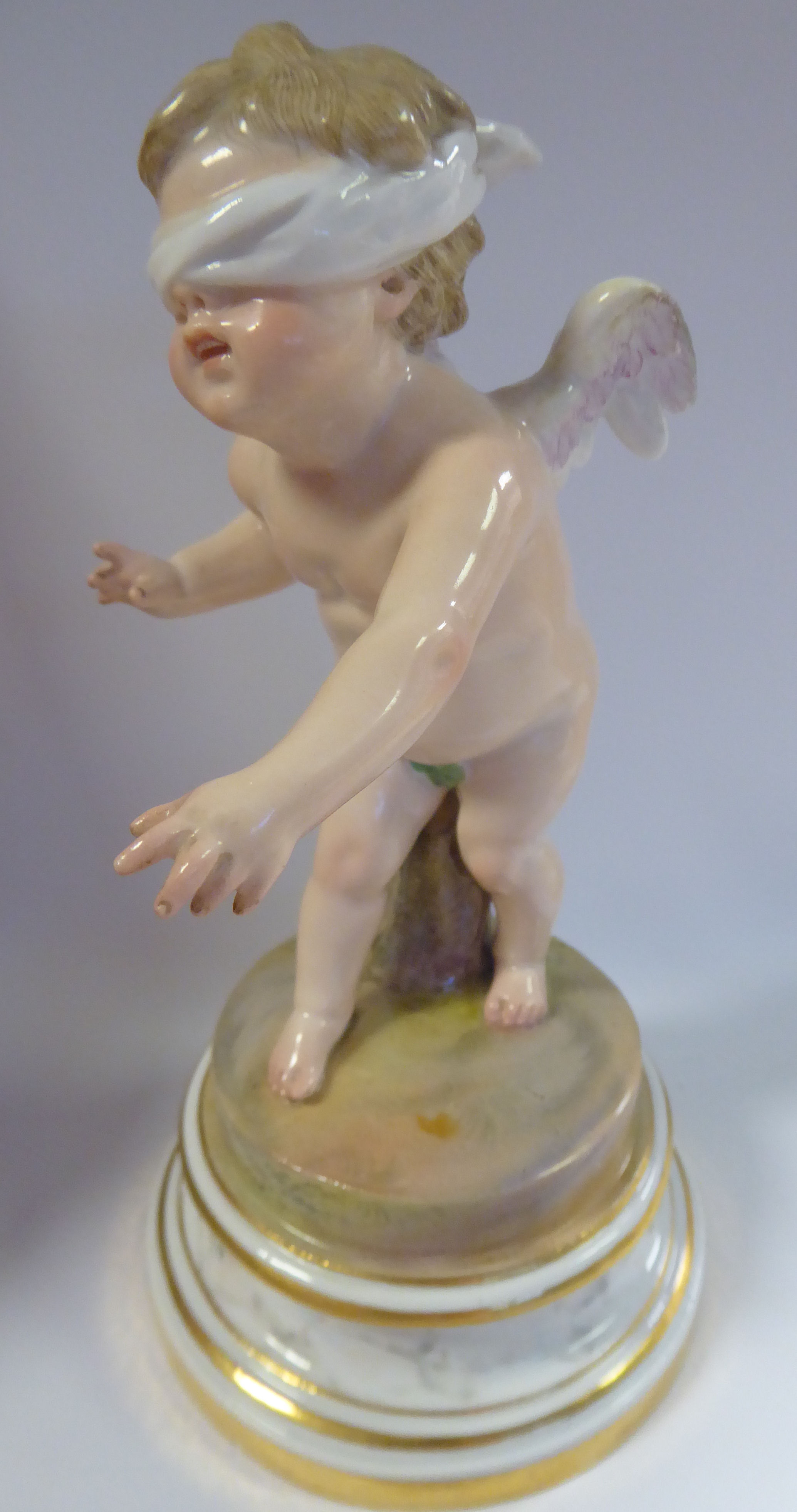 A Meissen porcelain figure 'Cupid Blindfolded' on a gilded,