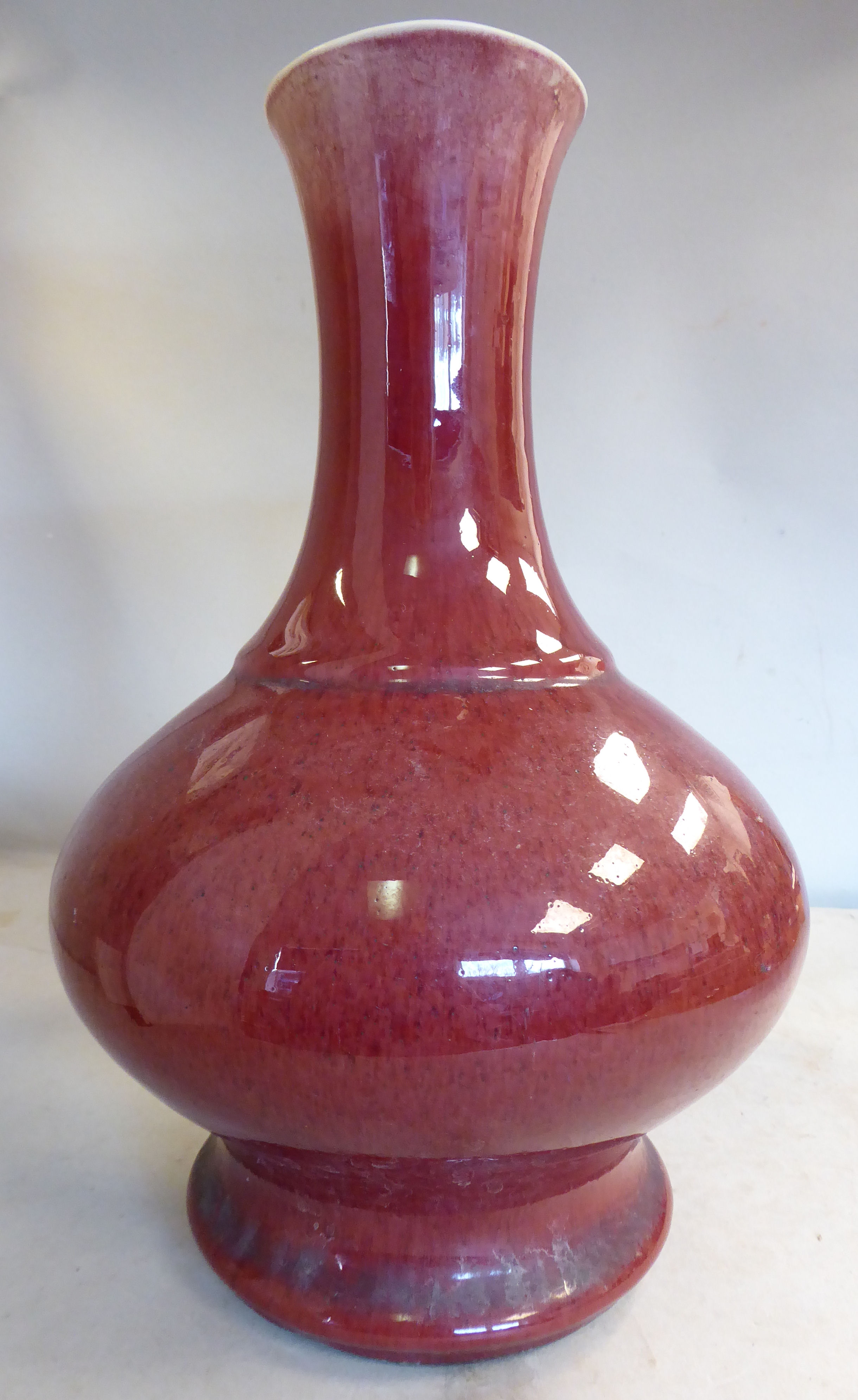 A 20thC Chinese sang du boeuf porcelain bulbous bottle vase with a bearing waisted neck 11.